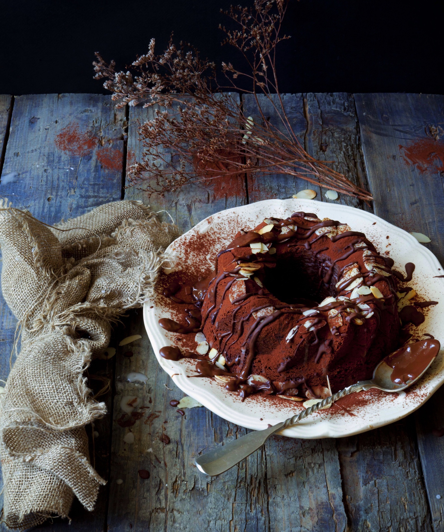 chocolate cake dusted with cocoa powder served on white place on a rustic table setting