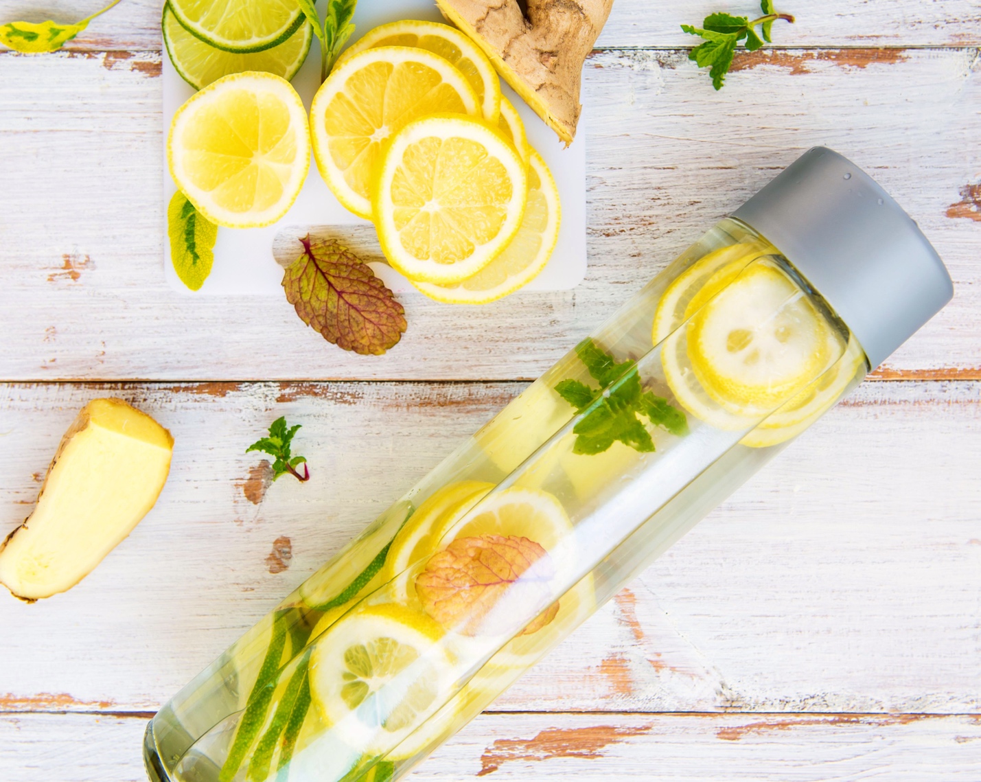 a bottle of clear water infused with fresh lemon slices and herbs